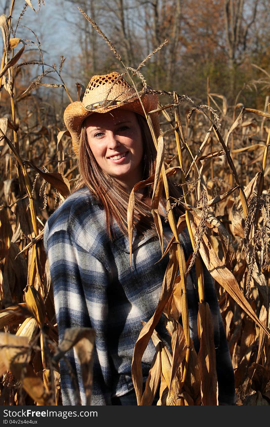 Pretty young girl in the middle of a corn field enjoying a beautiful day in autumn. Pretty young girl in the middle of a corn field enjoying a beautiful day in autumn.