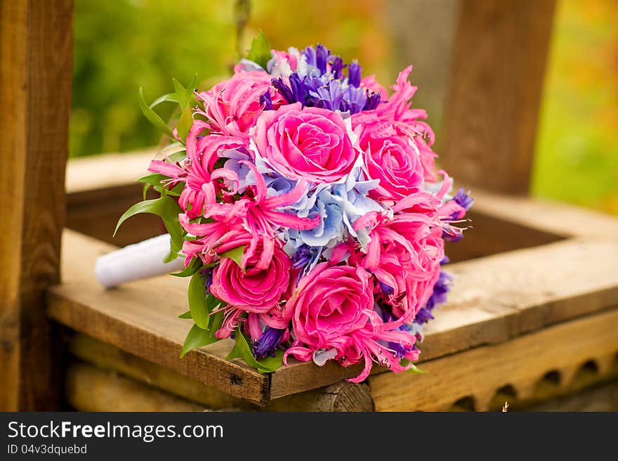 Bride's flower bouquet lying on a wooden well. Bride's flower bouquet lying on a wooden well