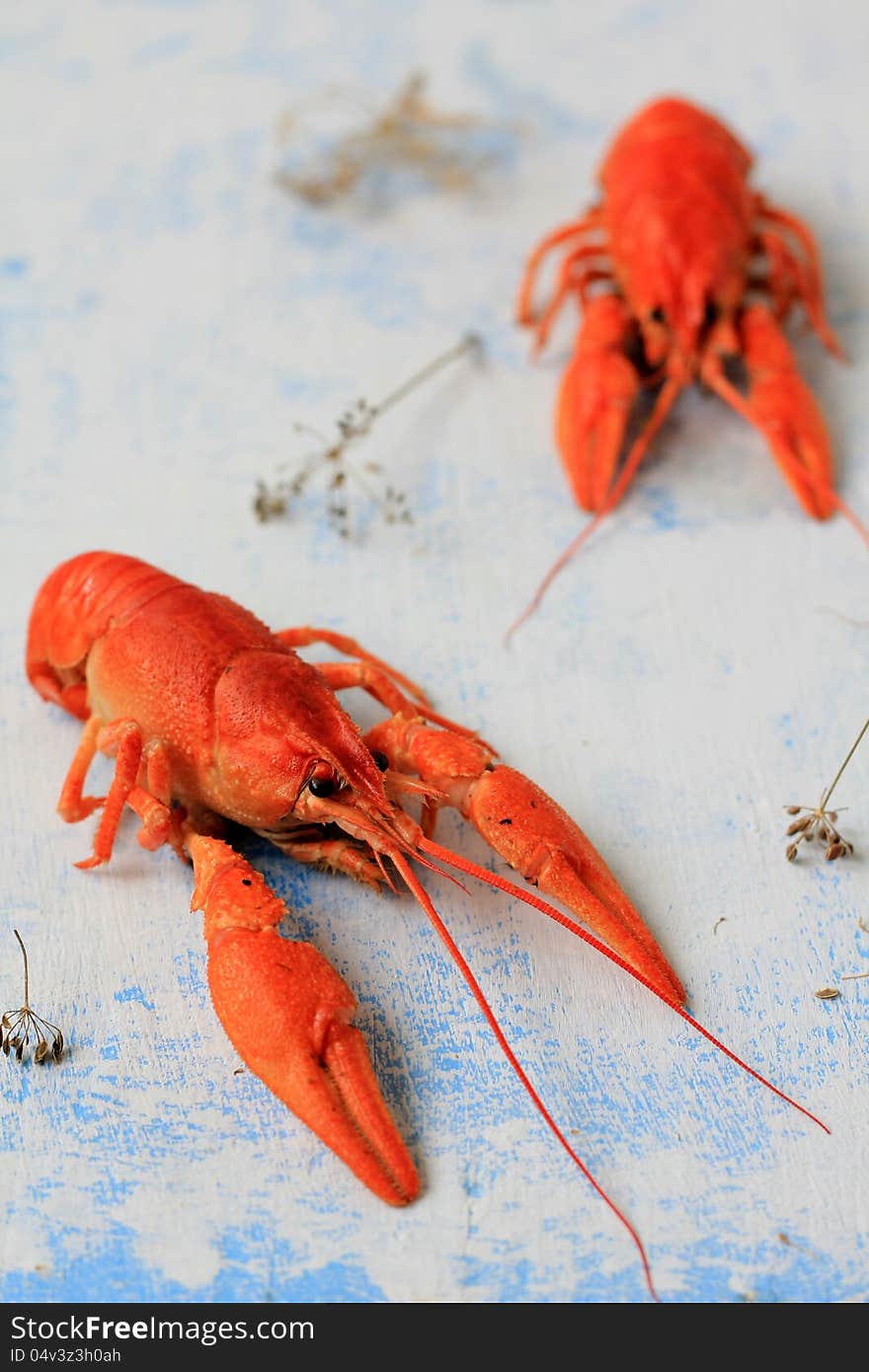 Two boiled crawfish on weathered wood.