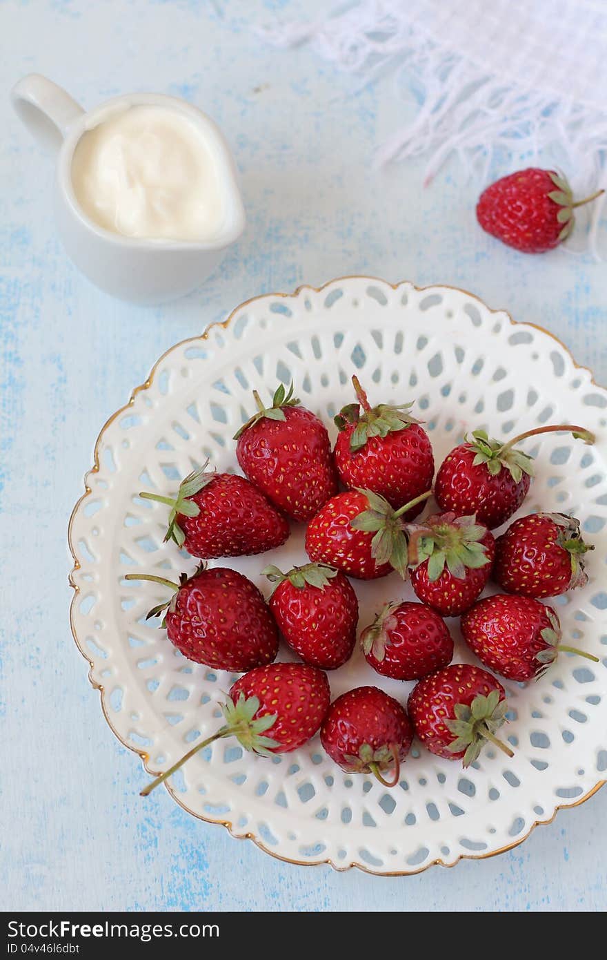 Plate with berries of a fresh strawberry and a sauceboat with yoghurt (sour cream). Plate with berries of a fresh strawberry and a sauceboat with yoghurt (sour cream)