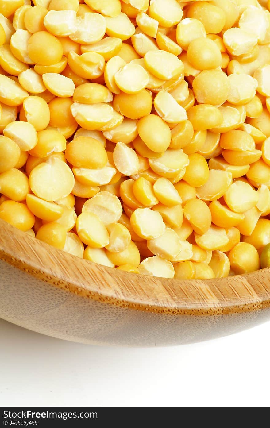 Yellow Split Peas in Wood Bowl closeup on white background