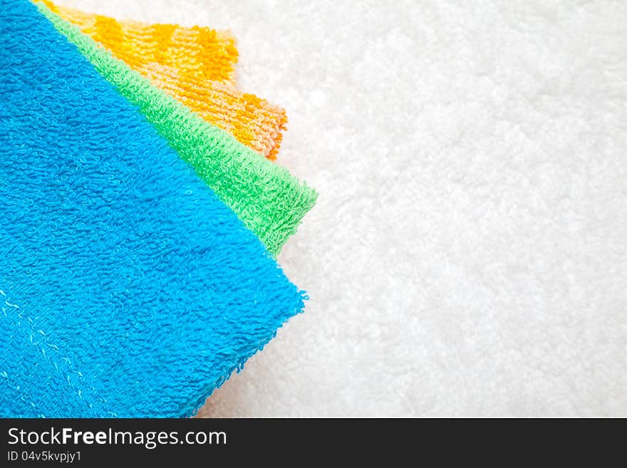 Stacked colorful towels isolates over white. Stacked colorful towels isolates over white