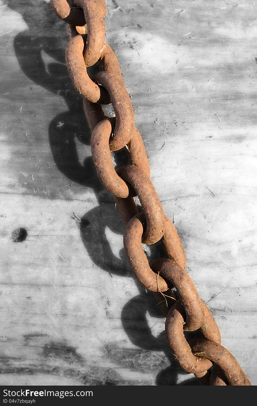 Strong rusty steel chain on the black and white wooden background. Strong rusty steel chain on the black and white wooden background