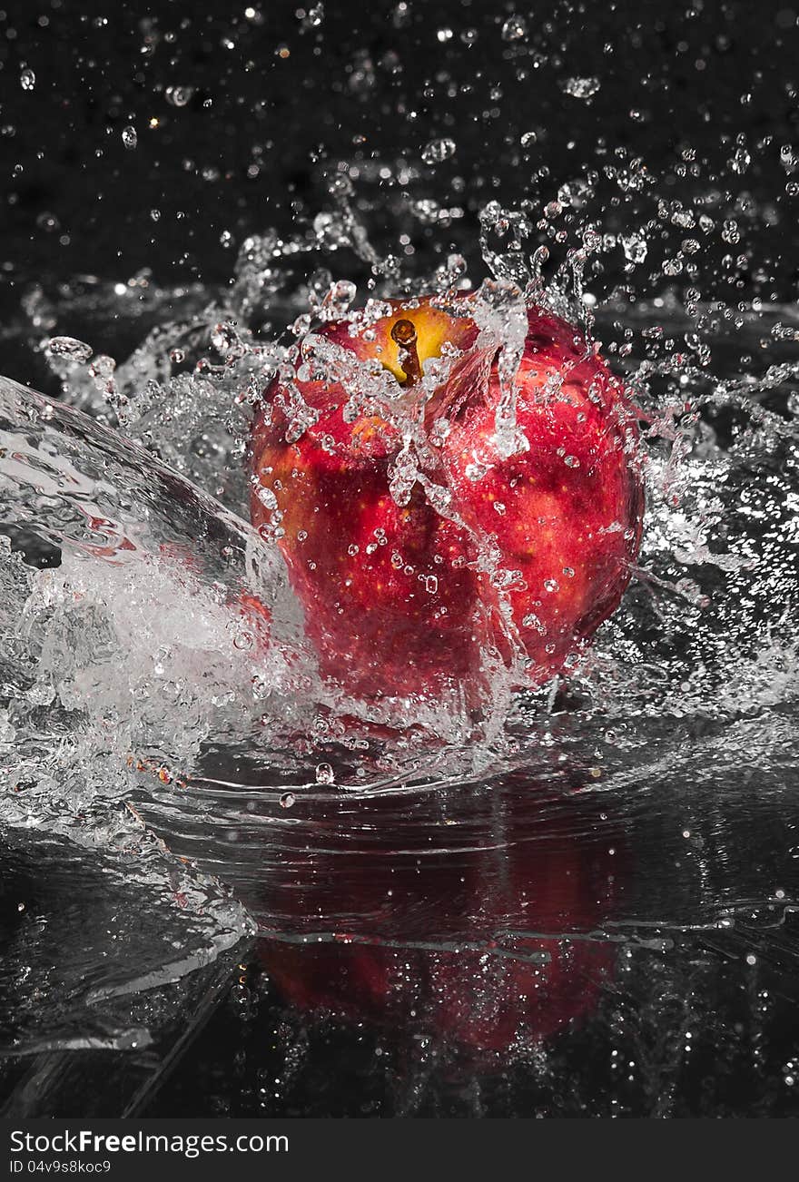 Fresh an apple in streaming splash water on black background. Fresh an apple in streaming splash water on black background