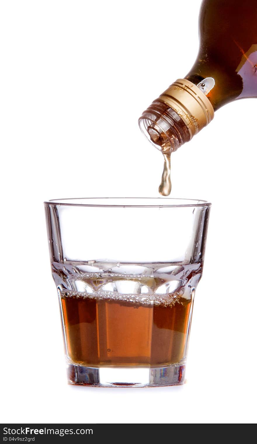 Whiskey being poured into a glass on white background