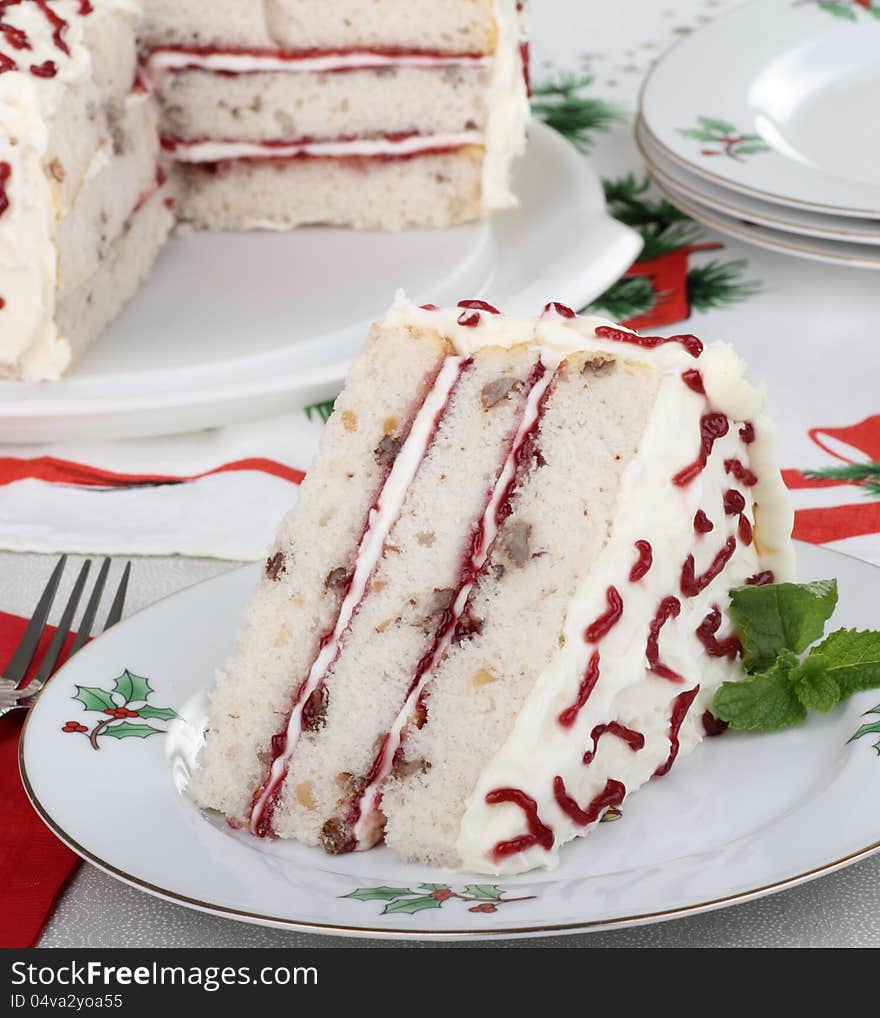 Piece of white layer cake on a Christmas plate. Piece of white layer cake on a Christmas plate