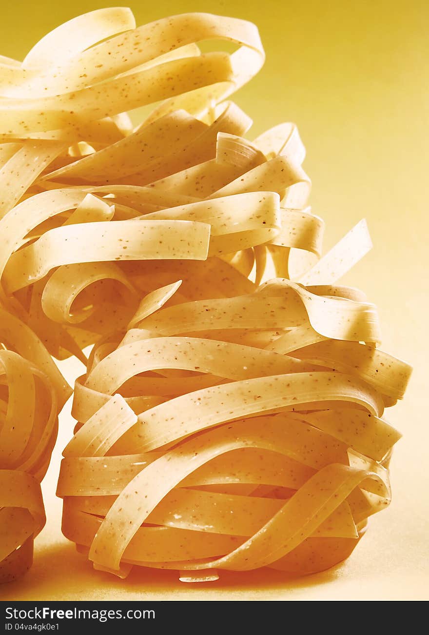 Italian pasta fettuccine on yellow gradient surface