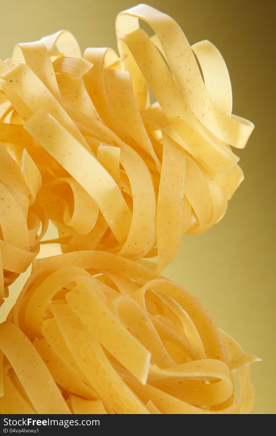 Italian pasta close-up on yellow gradient surface.