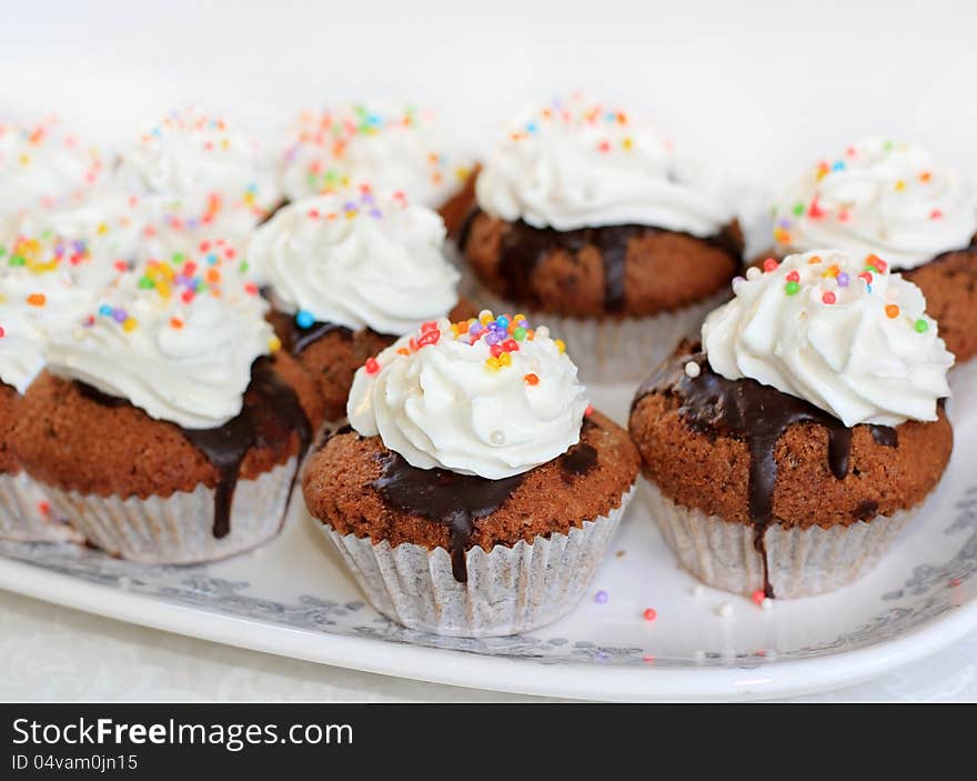 Chocolate cupcake topped with colorful sweet beads and whipped cream. Chocolate cupcake topped with colorful sweet beads and whipped cream