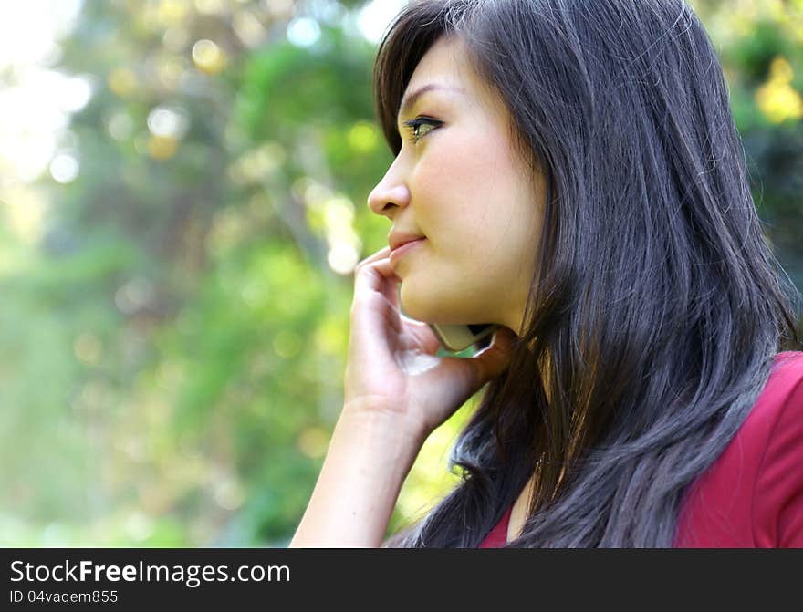 Pretty woman making a phone call in the garden