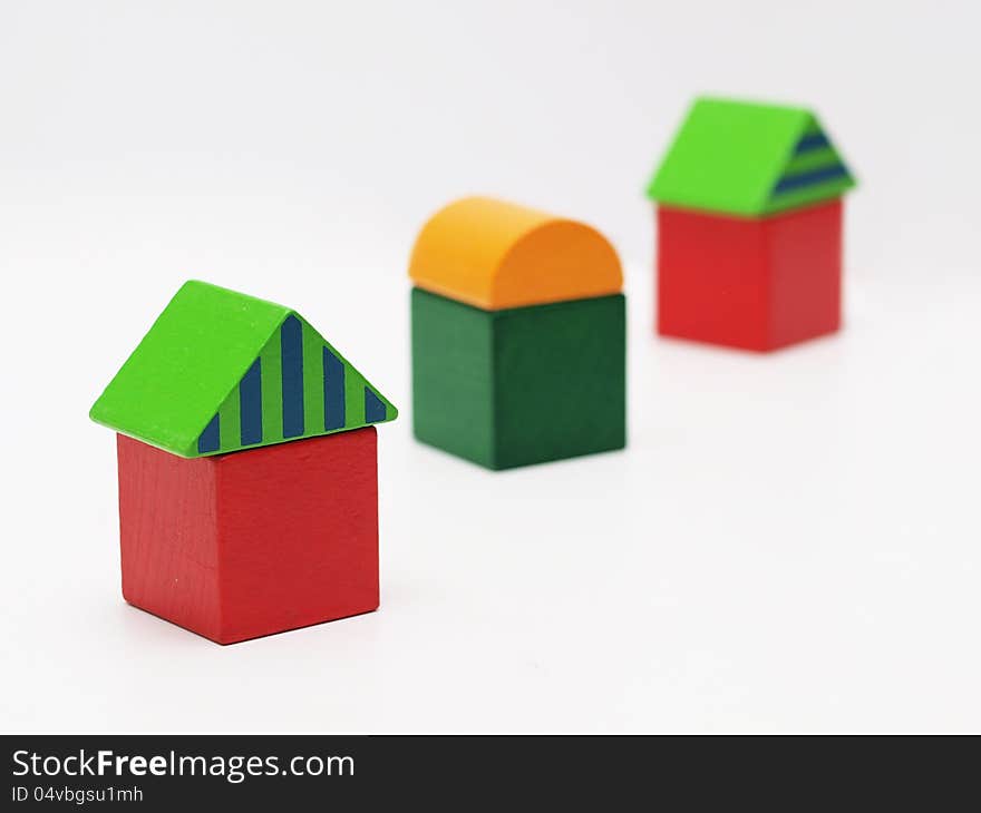 Three toy houses made of wooden blocks