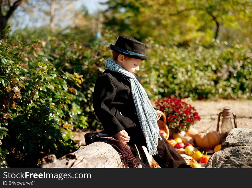 Boy in a black coat and hat at the picnic. Boy in a black coat and hat at the picnic