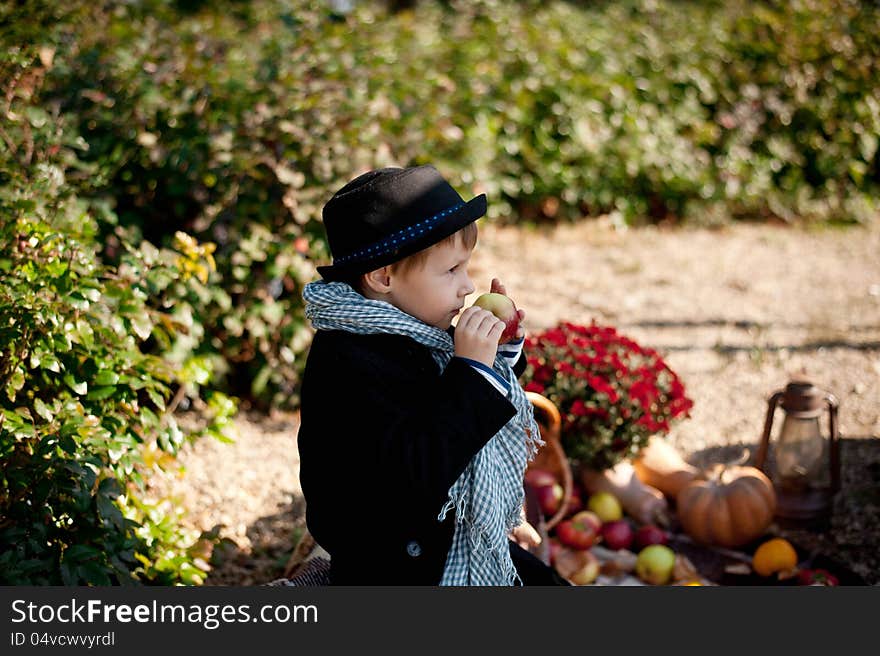 Boy in a black coat and hat at the picnic. Boy in a black coat and hat at the picnic