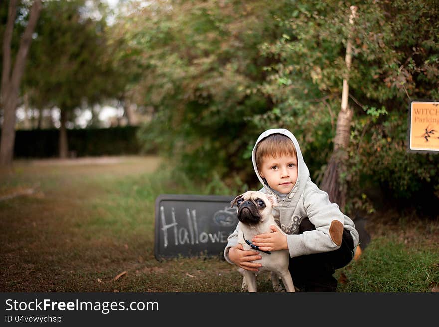 The nature boy hugs his beloved dog breed pug. The nature boy hugs his beloved dog breed pug