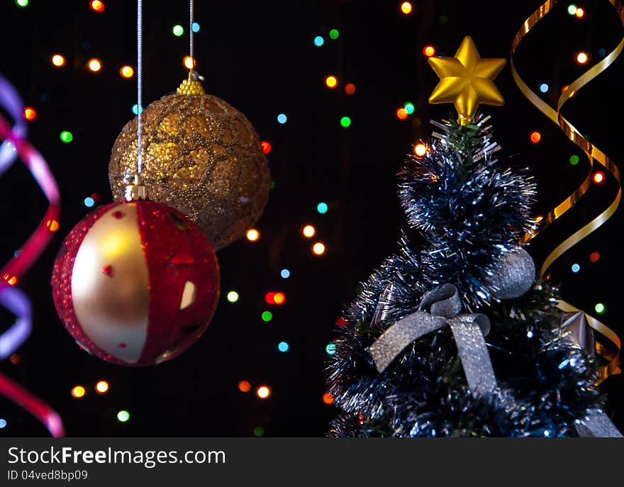 Two Christmas tree ball,the serpentine,a decorated Christmas tree on a black background with lights. Two Christmas tree ball,the serpentine,a decorated Christmas tree on a black background with lights