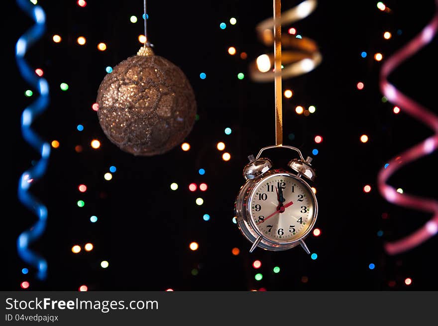 Clock,serpentine,Christmas ball on a black background with lights