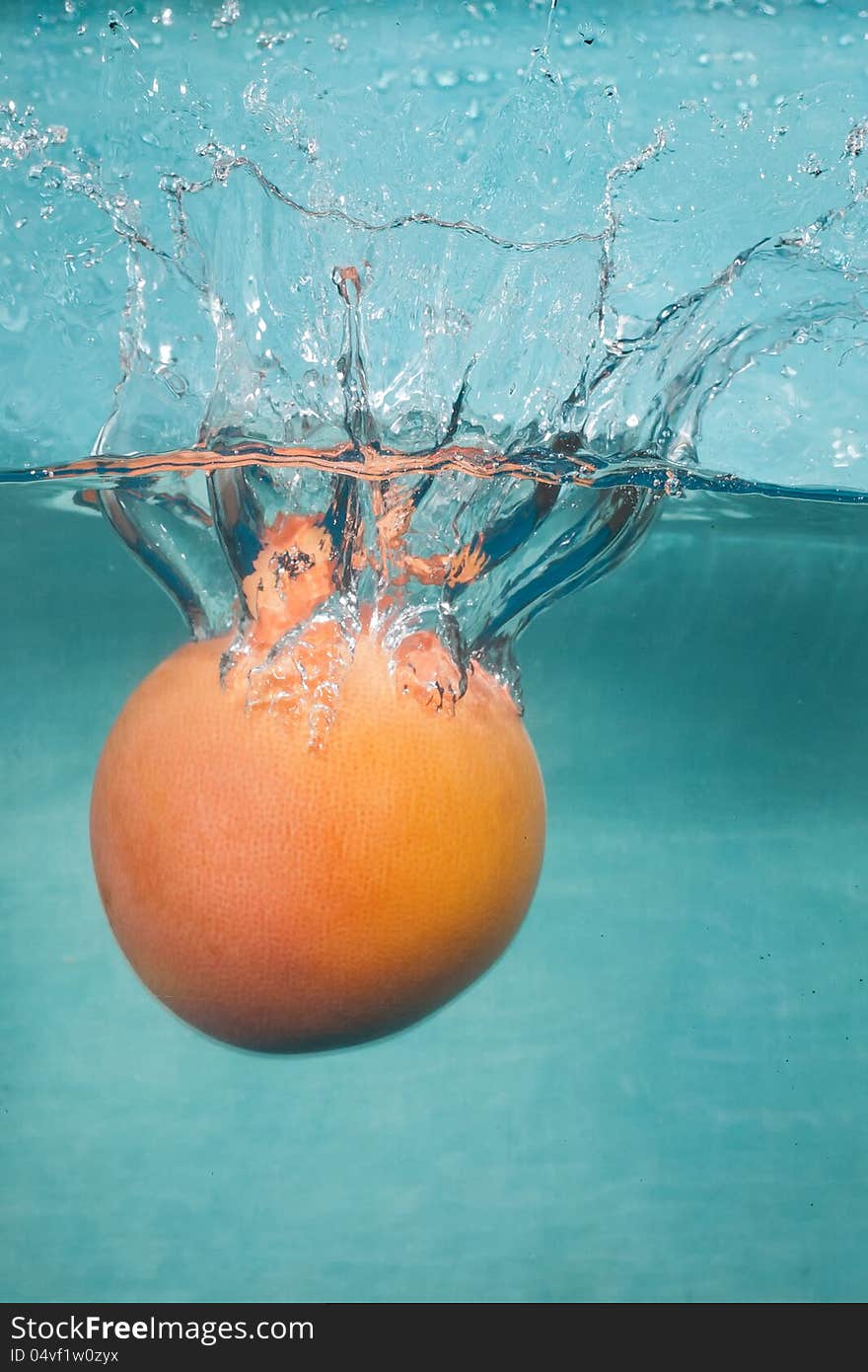 Water splash grapefruit on blue background