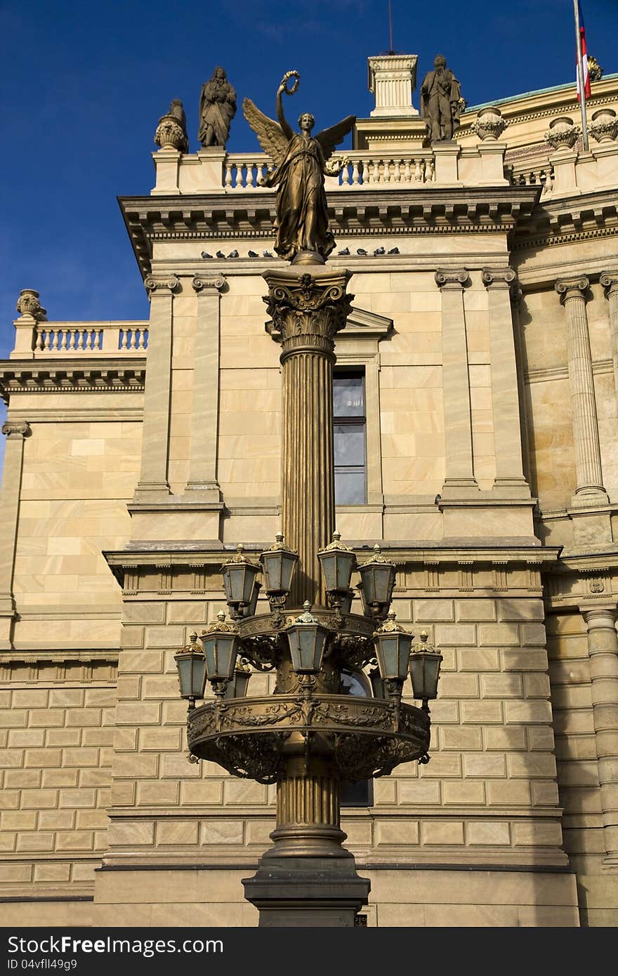 Old street lamp in front of the rudolfinum in prague, lamp with a statue