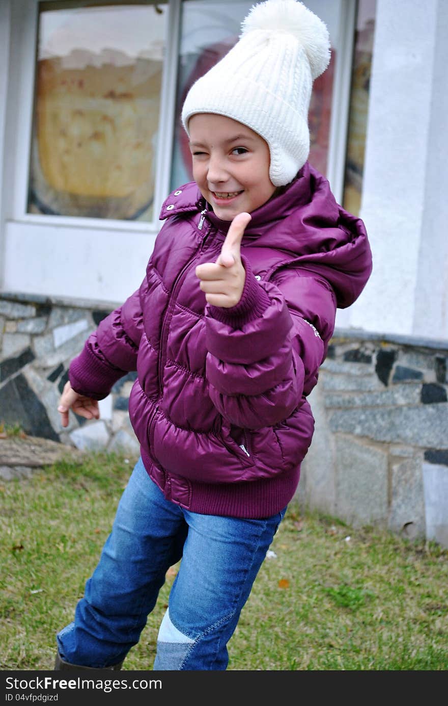 Glad small girl shows gesture that all well