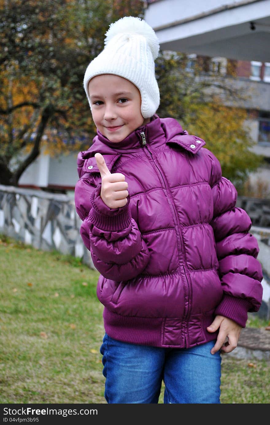 Glad small girl shows gesture that all well. Glad small girl shows gesture that all well