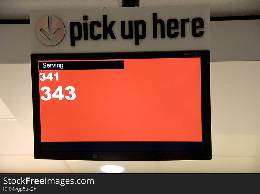 A pick up sign with screen displaying serving numbers