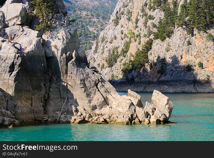 High mountains with trees growing on them and the blue lake. High mountains with trees growing on them and the blue lake