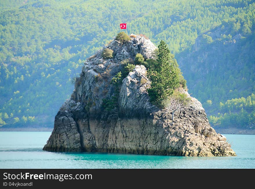 High mountains with growing trees and blue sky and lake. High mountains with growing trees and blue sky and lake