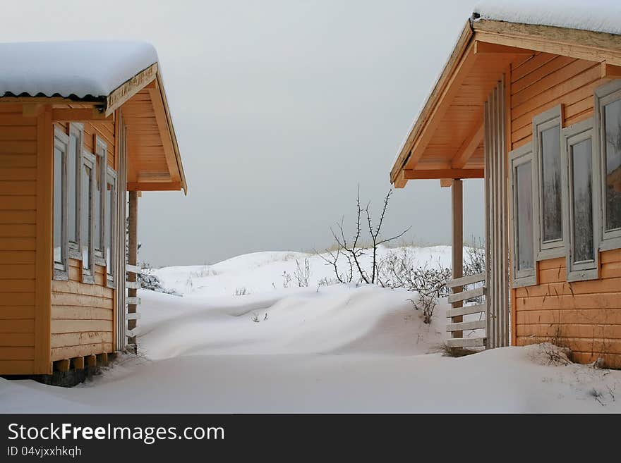 Two little wooden cottages in winter