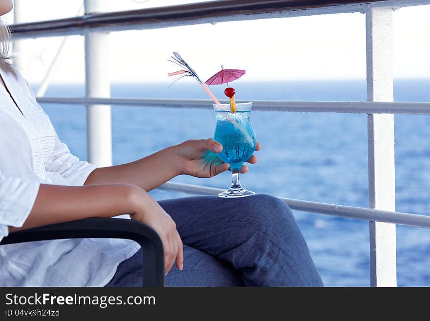 Girl drinking a cocktail on a journey to the sea