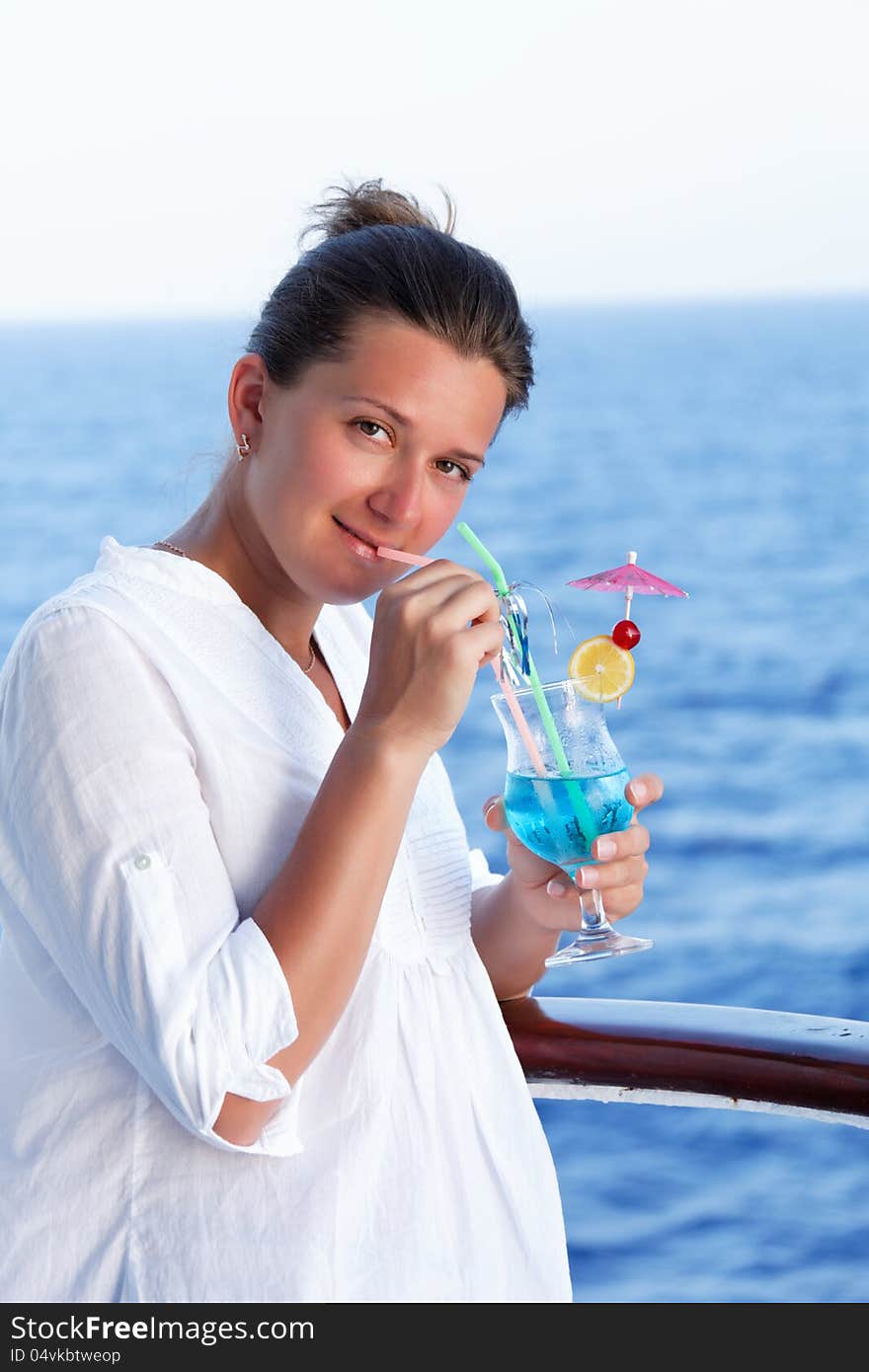 Cute brunette girl enjoys traveling on a ship at sea