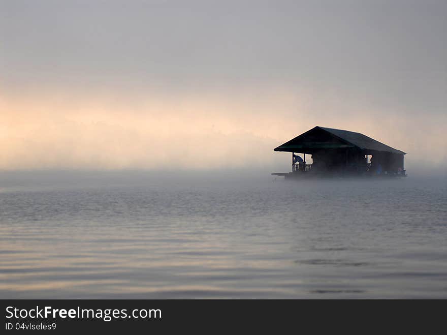 Floating home in the morning fog.It's a floating house for tourists.Samprasobriver Sangkhlaburi thailand.