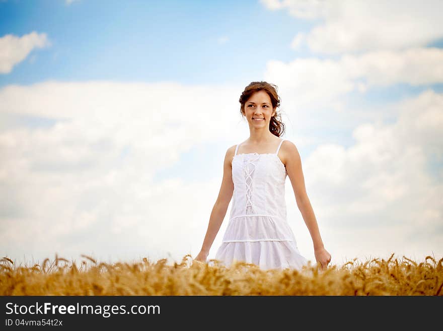 Smiling woman in white dress in field