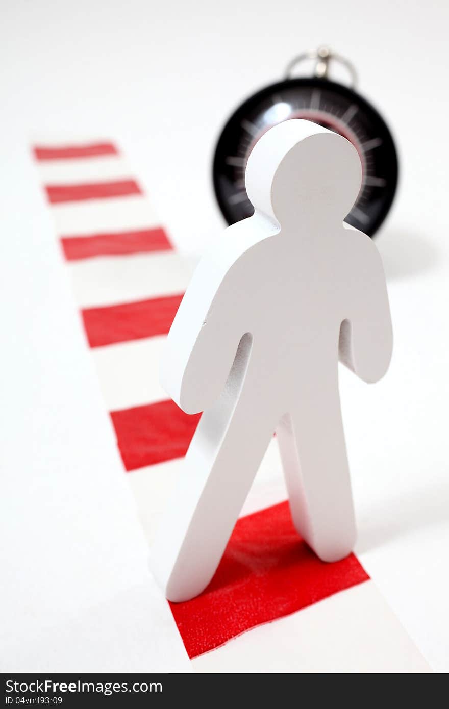 Wooden figute standing on chevron in front of a clock. Wooden figute standing on chevron in front of a clock.