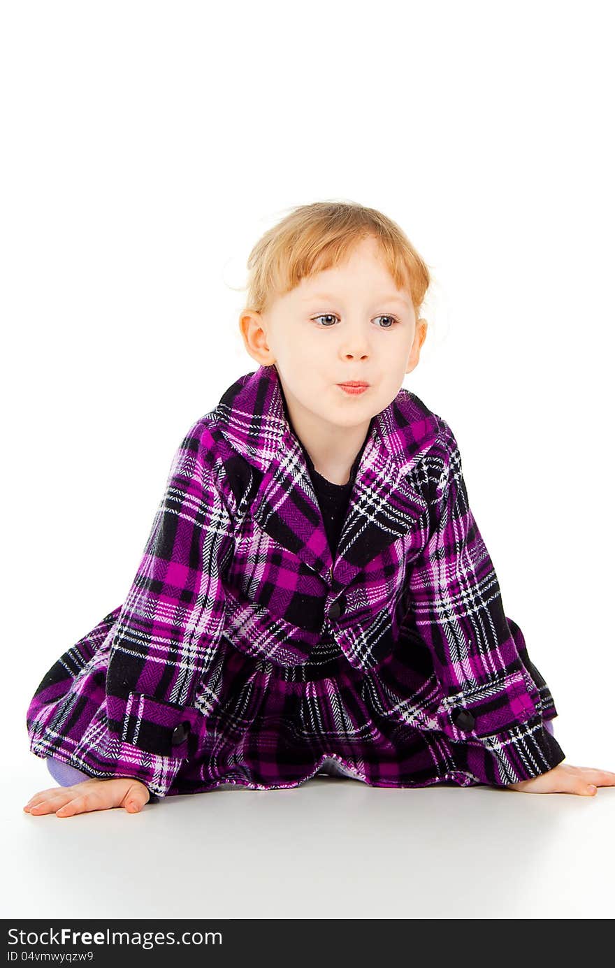 A little girl in a dress, have fun, sits isolated on white background