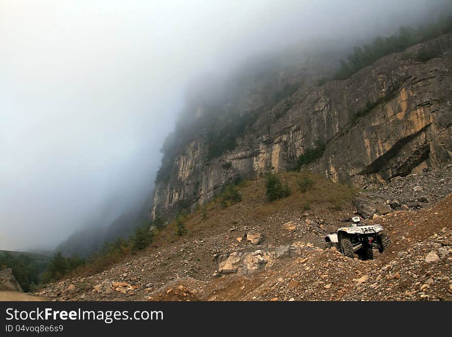 Quad stands in the fog in the mountains. Quad stands in the fog in the mountains