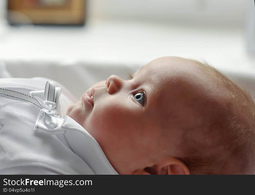 On a white background cute baby lying in a beautiful dress. On a white background cute baby lying in a beautiful dress