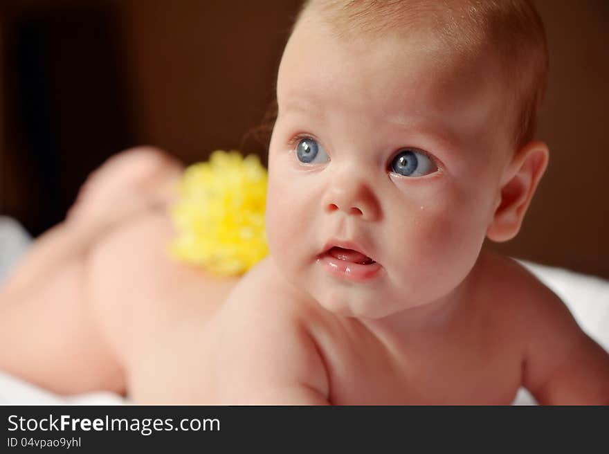 Lays bare a beautiful baby with yellow flower on her back