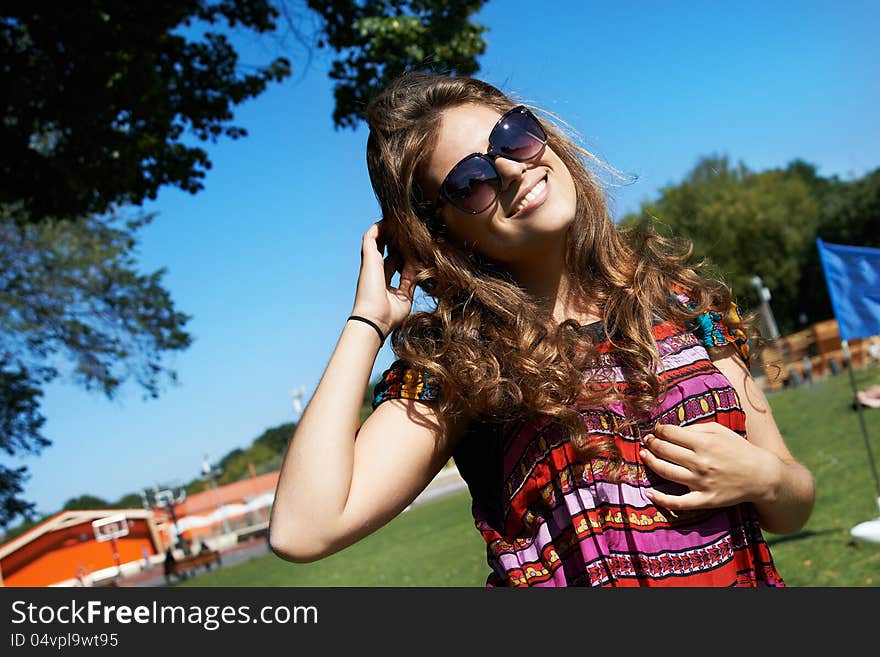 Attractive girl in sunglasses in summer park