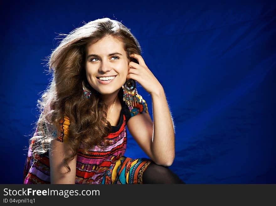 Beautiful young woman with long hair on a blue background