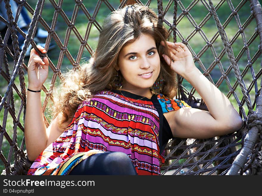 Beautiful young woman with long hair in a hammock in park. Beautiful young woman with long hair in a hammock in park