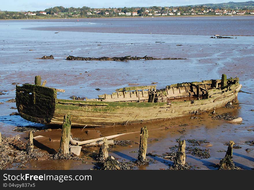Old rotting rowing boat at low tide at Exmouth Bay. Old rotting rowing boat at low tide at Exmouth Bay
