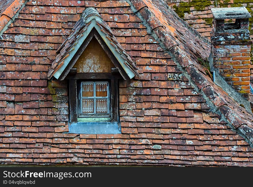 Old brick roof with window and a chimney