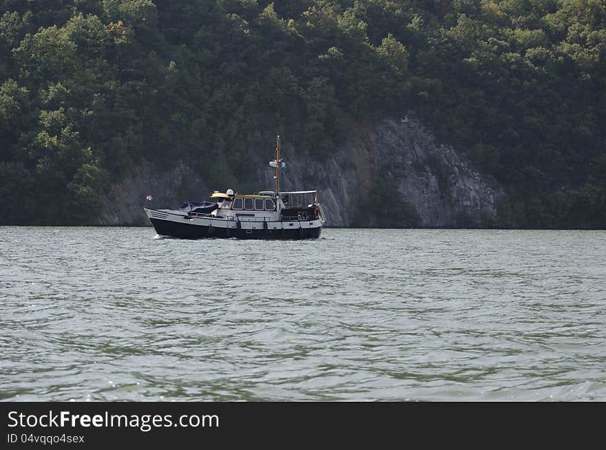 A solitary boat cruising the Danube river at Cazane gorge. A solitary boat cruising the Danube river at Cazane gorge