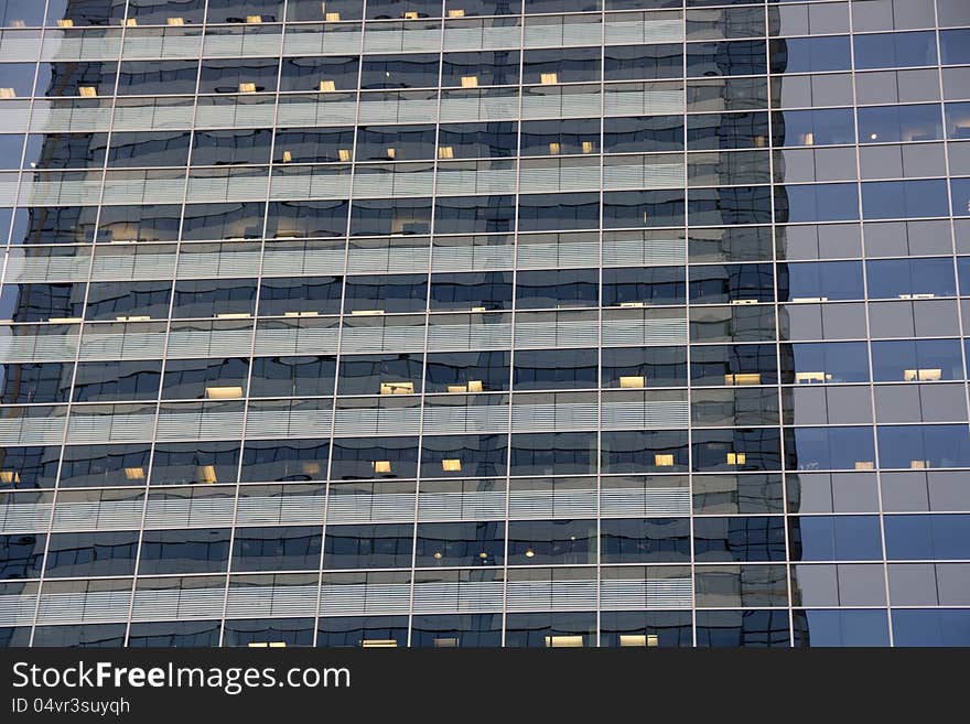 An office building with clear windows and lights. The repetition and reflection make it an interesting image. An office building with clear windows and lights. The repetition and reflection make it an interesting image.