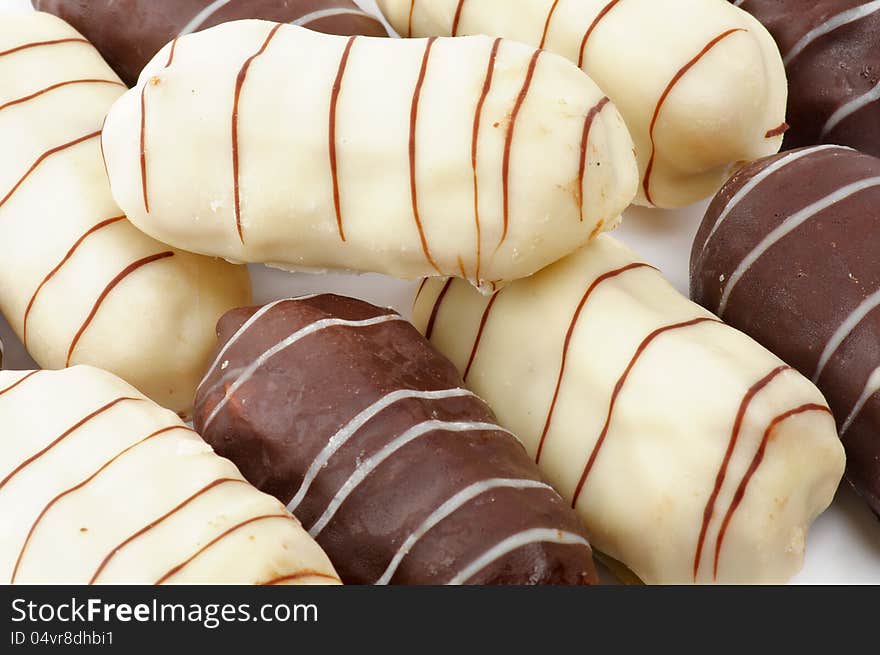 Background of Eclairs with White and Black Chocolate Glaze closeup. Background of Eclairs with White and Black Chocolate Glaze closeup