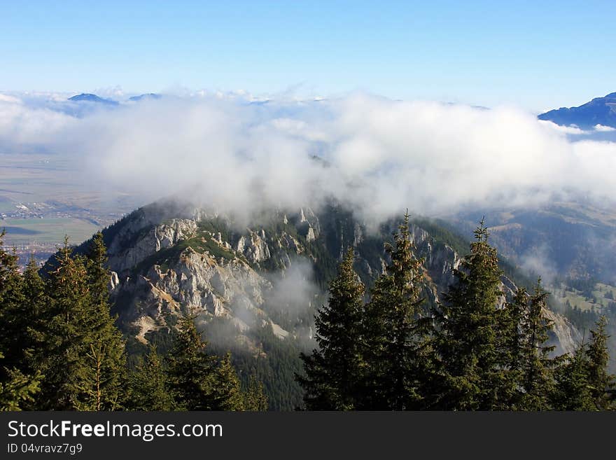 This image presents a spectacular view from the top of a peak in Piatra Craiului mountains in Romania. This image presents a spectacular view from the top of a peak in Piatra Craiului mountains in Romania.