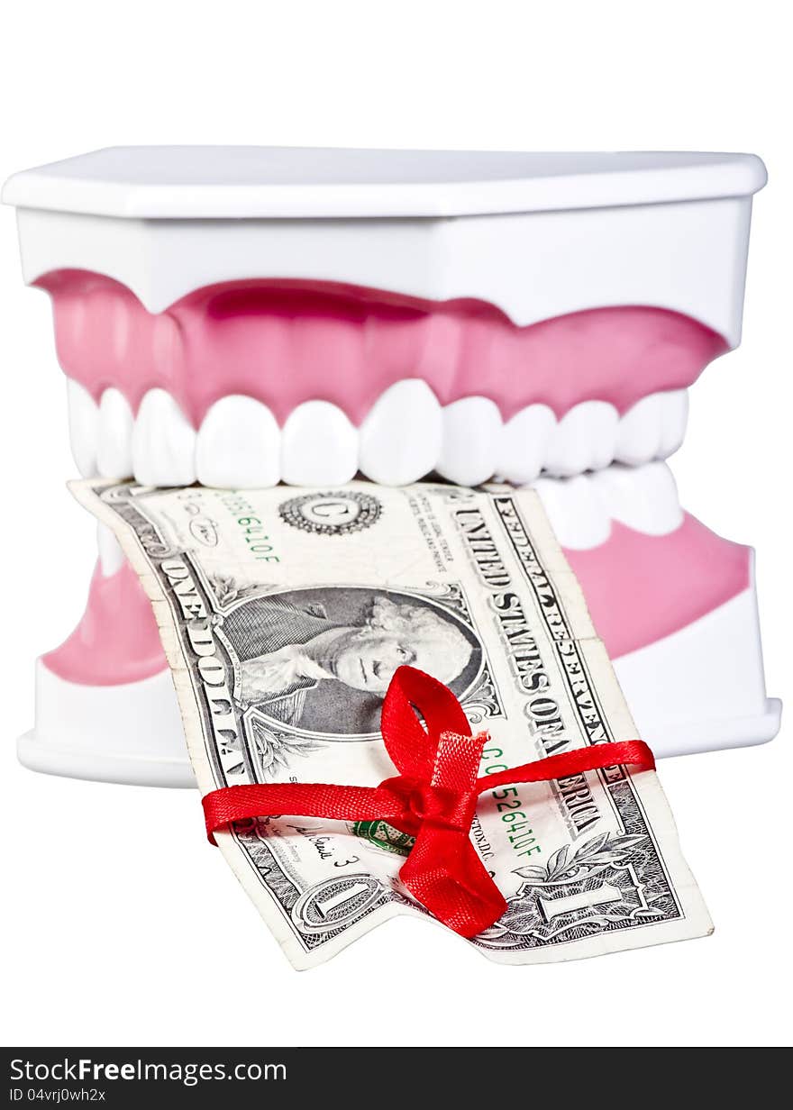 Artificial human jaw with one dollar tied up with a red bow.