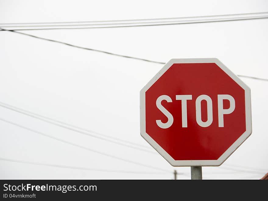 Stop traffic sign with sky and some cables in the background. Stop traffic sign with sky and some cables in the background.