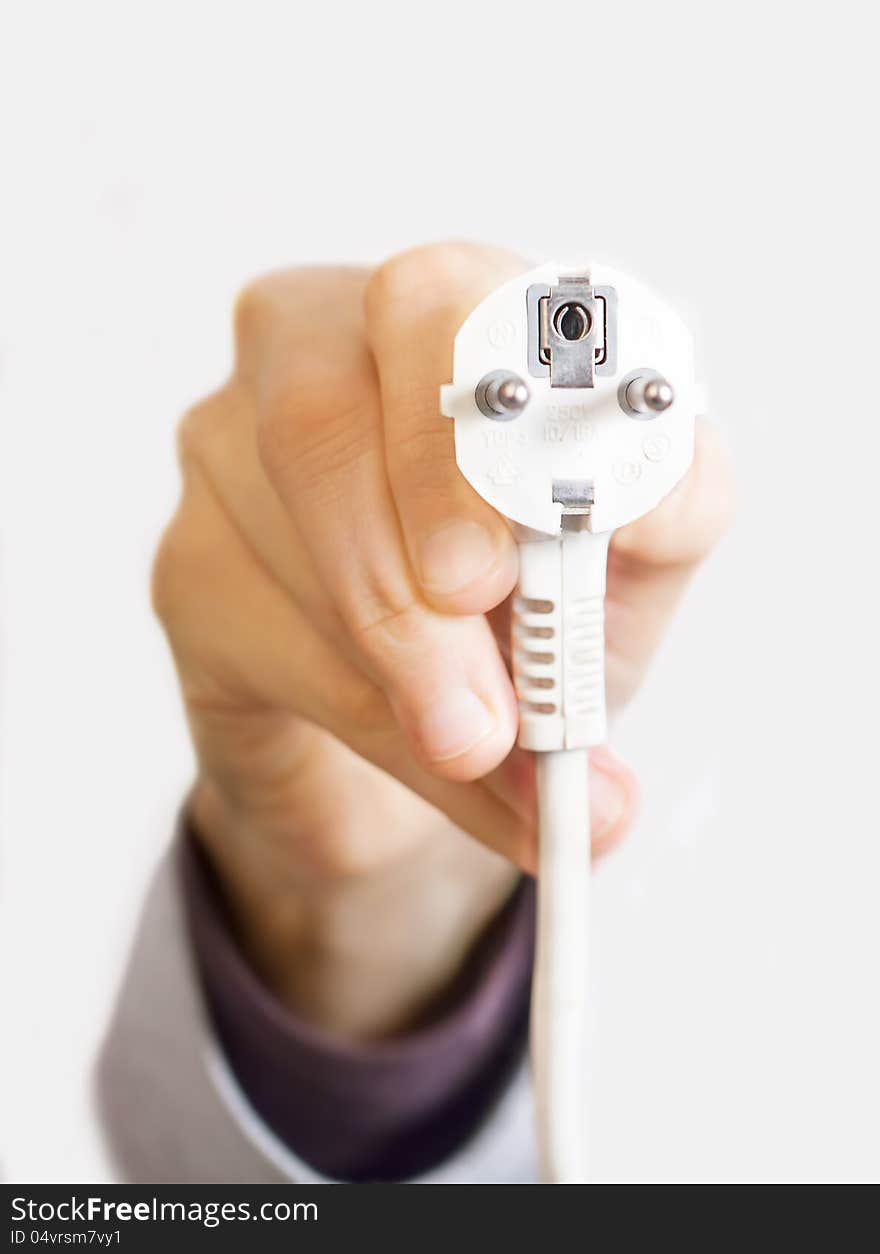 Hand holding plug connector on white background