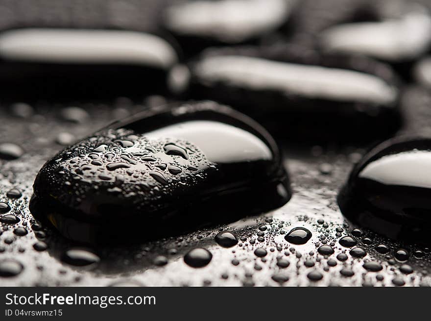 Spa background. Black stones with water drops